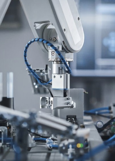 Industrial robot arm with gripper on an automated assembly line